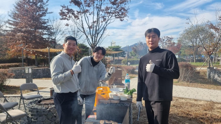 야외 캠핑장에서 고기 굽고 있는 형제들